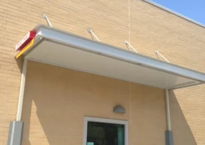 Drive-thru service window on the side of a building with clear skies above.