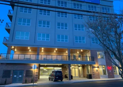 Modern residential building with illuminated balconies during dusk.