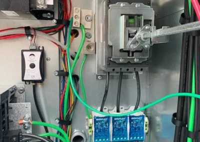 An electrical enclosure with neatly organized wires, circuit breakers, and connections.